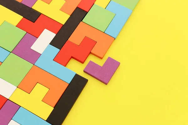 Un colorato puzzle quadrato tangram, sopra tavolo di legno — Foto Stock