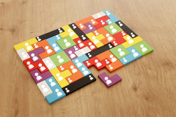 Bild von Tangram-Puzzlebausteinen mit Menschen-Symbolen über Holztisch, Personalwesen und Managementkonzept — Stockfoto