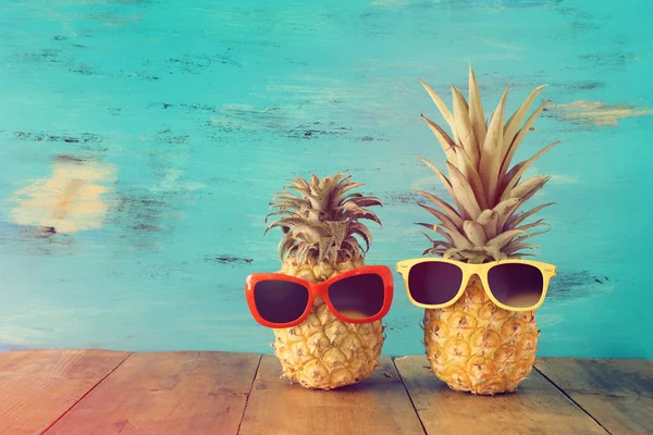 Pareja madura de piña en gafas de sol con estilo sobre mesa de madera o cubierta, relajante. Concepto de vacaciones de verano tropical — Foto de Stock