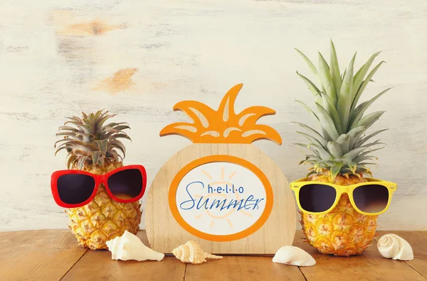 Pareja madura de piña en gafas de sol con estilo sobre mesa de madera o cubierta, relajante. Concepto de vacaciones de verano tropical — Foto de Stock