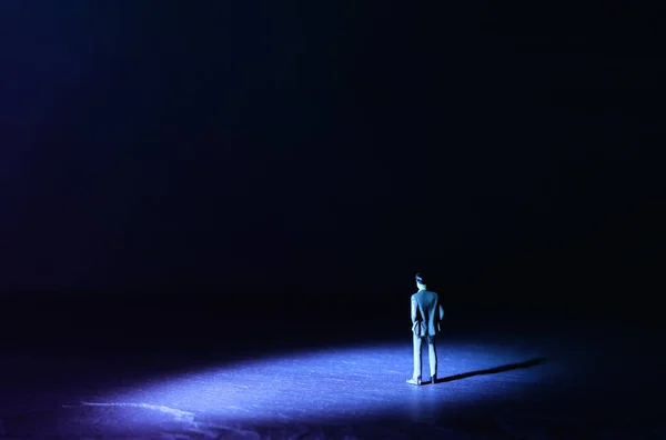 Une photo d'un homme miniature se tient sous les projecteurs vers l'avenir.Concept de faire face à l'inconnu, de prendre une décision et de trouver une solution . — Photo