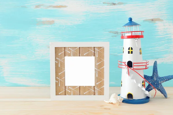 空のフォト フレームと木製のテーブルの上の灯台海事のコンセプトです。写真のモンタージュのため — ストック写真