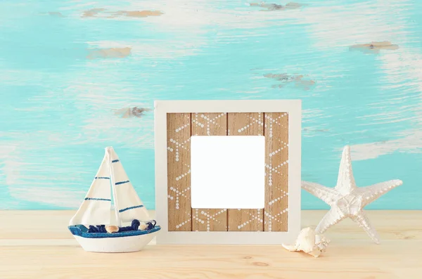 Námořních koncept s prázdnou Foto rámeček a plachty lodí přes dřevěný stůl. Pro fotografie montage — Stock fotografie