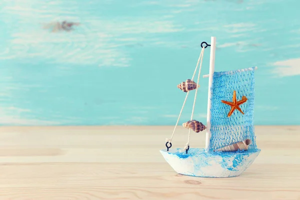 Vintage boat over wooden table or shelf and pastel blue background — Stock Photo, Image