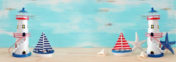 Semester och sommar koncept med Vintage båt, sjöstjärna, fyr och snäckskal över träbord eller hylla Infront av pastellblå bakgrund. Banner — Stockfoto