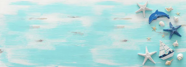 Vakantie en zomer concept met vintage boot, zeesterren en schelpen over pastel blauwe houten achtergrond. Bovenaanzicht platte lag — Stockfoto