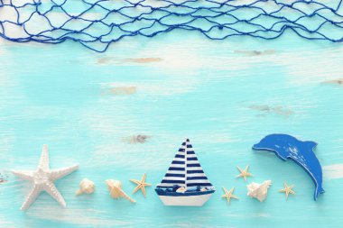 antika tekne, fishnet, yıldız balığı ve pastel mavi ahşap arka plan üzerinde deniz kabukları ile tatil ve yaz konsepti. Üst görünüm düz yatıyordu