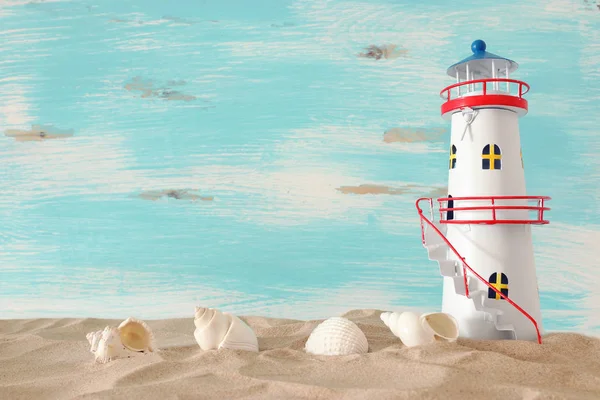 Vacances et concept d'été avec bateau vintage, étoile de mer, phare et coquillages sur la plage de sable devant fond bleu pastel — Photo