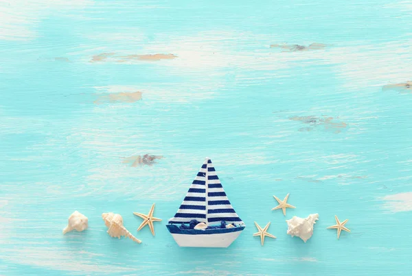 パステルブルーの木製の背景の上にヴィンテージボートと貝殻と休暇と夏のコンセプト。トップビューフラットレイ — ストック写真