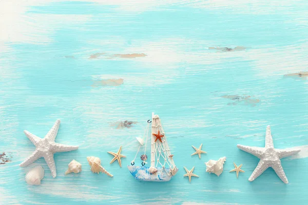 Vacation and summer concept with vintage boat, starfish and seashells over pastel blue wooden background. Top view flat lay — Stock Photo, Image