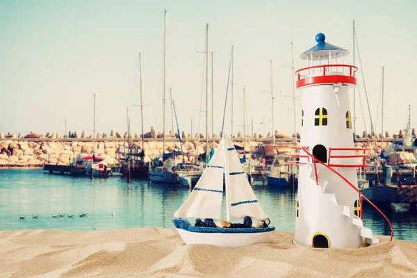 Oldtimer-Holzboot und Leuchtturm über Sand und Meer — Stockfoto