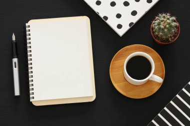 Siyah ofis masası masa üzerinde boş sayfalar ve diğer ofis malzemeleri ile dizüstü açık. Üstte görüntü