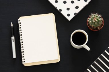 Siyah ofis masası masa üzerinde boş sayfalar ve diğer ofis malzemeleri ile dizüstü açık. Üstte görüntü