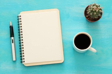 Mavi ofis masası üzerinde boş sayfalar ve diğer ofis malzemeleri ile defter açın. Üstte görüntü