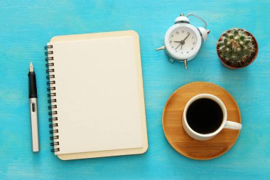 Mavi ofis masası üzerinde boş sayfalar ve diğer ofis malzemeleri ile defter açın. Üstte görüntü