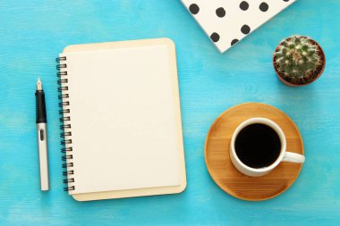 Mavi ofis masası üzerinde boş sayfalar ve diğer ofis malzemeleri ile defter açın. Üstte görüntü