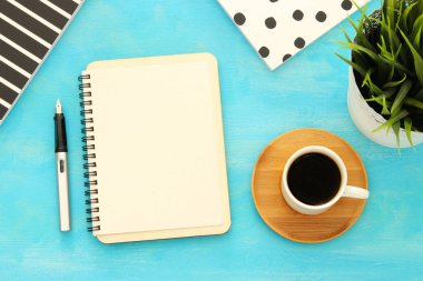 Mavi ofis masası üzerinde boş sayfalar ve diğer ofis malzemeleri ile defter açın. Üstte görüntü