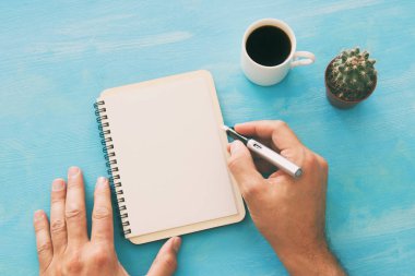 Mavi ofis masası üzerinde boş sayfalar ve diğer ofis malzemeleri ile defter açın. Üstte görüntü