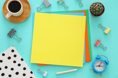 mavi ofis masası üzerinde renkli boş sayfalar ve diğer ofis malzemeleri. Üstte görüntü