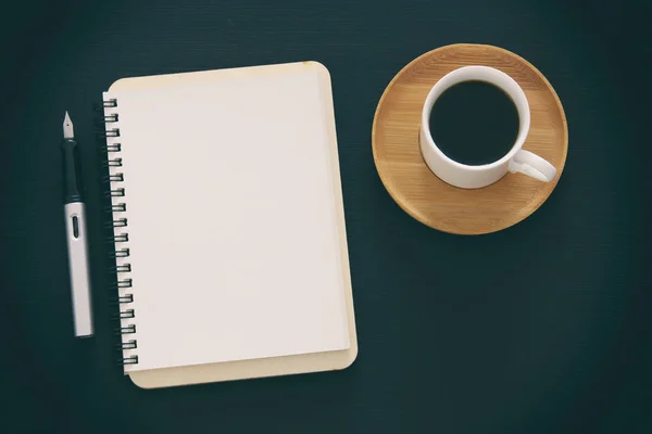 Abra el cuaderno con páginas vacías y otros suministros de oficina sobre la mesa de escritorio de oficina negra. Vista superior —  Fotos de Stock