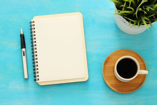 Ανοίξτε το σημειωματάριο με κενές σελίδες και άλλα αναλώσιμα γραφείου σε μπλε τραπέζι γραφείου. Κορυφαία προβολή — Φωτογραφία Αρχείου