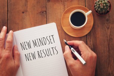 Tablonun açık defterli en üstteki görüntüsü ve yeni metin zihniyeti sonuçları. başarı ve kişisel gelişim kavramı