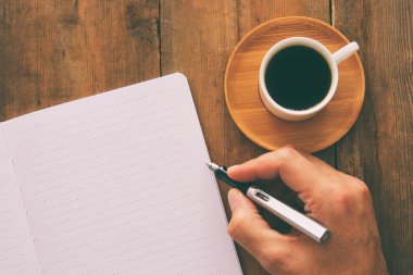 Ahşap eski ofis masası masa üzerinde boş sayfaları ve diğer ofis malzemeleri ile açık defter. Üst görünüm, düz yatıyordu