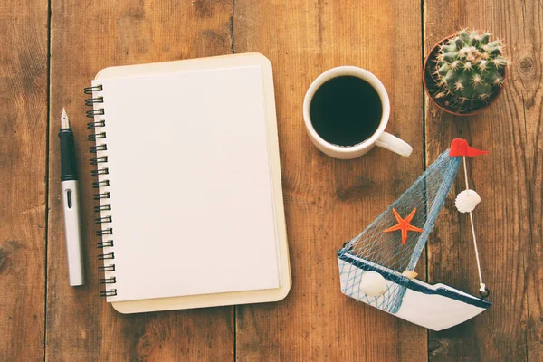 Cuaderno abierto con páginas vacías y otros suministros de oficina sobre la mesa de escritorio de madera antigua oficina. Vista superior, plano —  Fotos de Stock