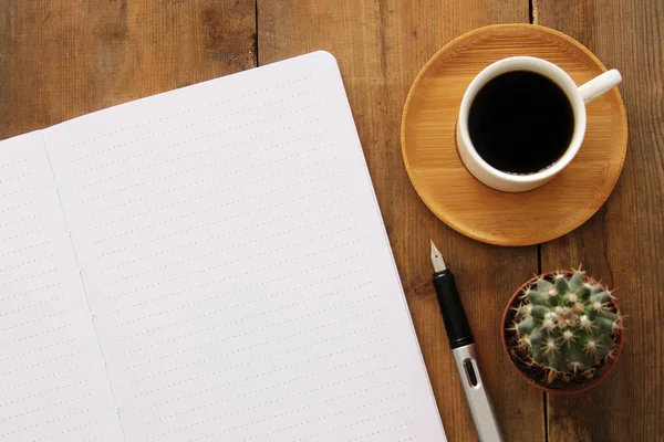 Open notebook with empty pages and other office supplies over wooden old office desk table. Top view, flat lay — Stock Photo, Image