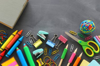 Okul konseptine geri dönelim. kırtasiye ve kitap sınıf kara tahta üzerinde. üst görünüm, düz yatıyordu