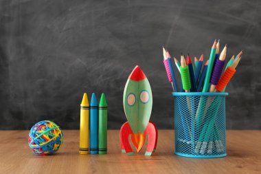 eğitim ve okul kavramına geri dön. sınıf kara tahta önünde karton roket ve kalem