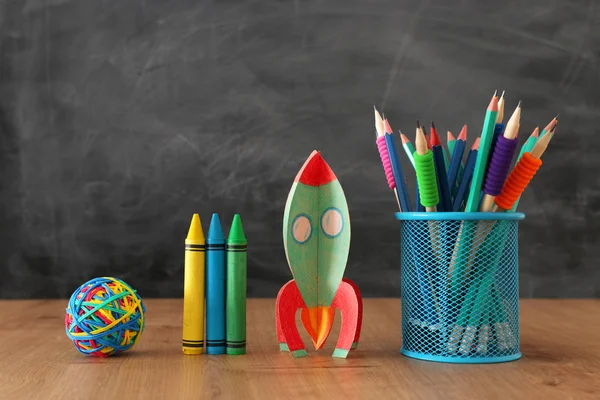 Educação e volta ao conceito de escola. foguete de papelão e lápis na frente da sala de aula quadro negro — Fotografia de Stock