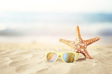 Tatil. kum plaj, güneş gözlüğü ve denizyıldızı kopya alanı ile yaz deniz arka plan önünde