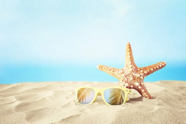 Vacaciones. playa de arena, gafas de sol y estrellas de mar en frente de fondo de mar de verano con espacio para copiar —  Fotos de Stock