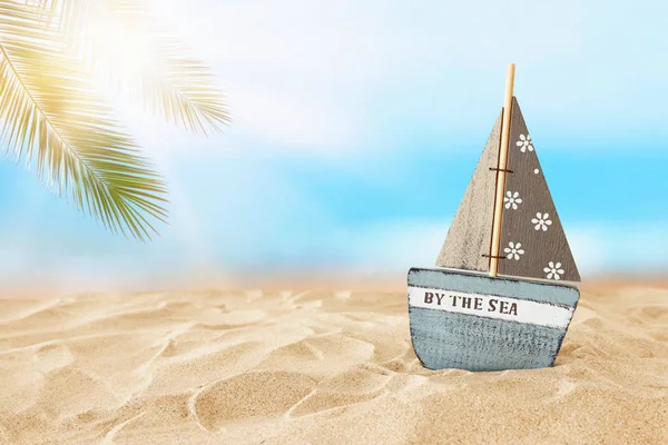 holidays. vintage wooden boat over beach sand and sea landscape background