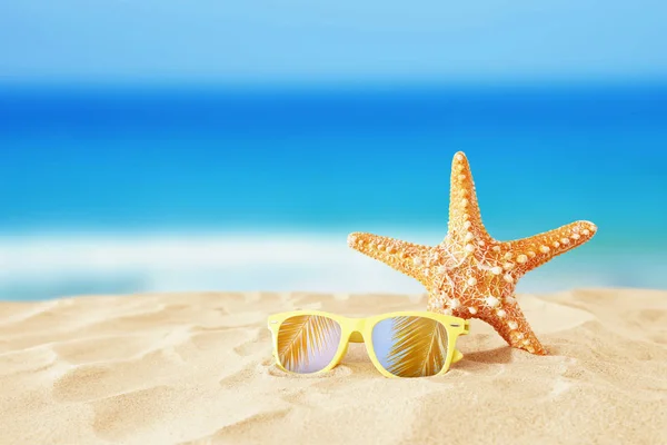 Праздники. песчаный пляж, солнцезащитные очки и морская звезда на фоне летнего моря с копировальным пространством — стоковое фото