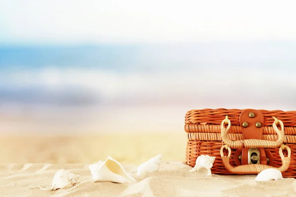 Праздники. Пляжный соломенный чемодан и деревянная лодка в песке. Концепция тропических летних каникул — стоковое фото