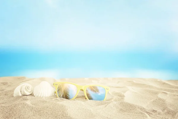 Playa de arena vacía, conchas marinas y gafas de sol en frente del verano se — Foto de Stock