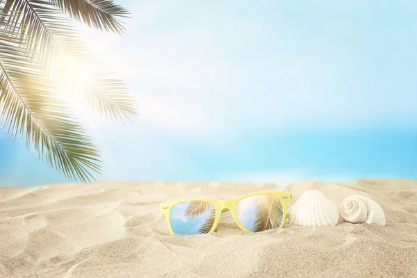 Tom sandstrand, snäckskal och solglasögon framför sommar havet bakgrund med kopia utrymme — Stockfoto