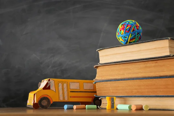 Educação e volta ao conceito de escola. ônibus de papelão, livros e giz na frente da sala de aula quadro negro — Fotografia de Stock