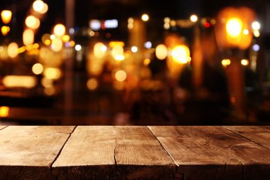 background of wooden table in front of abstract blurred restaurant lights clipart