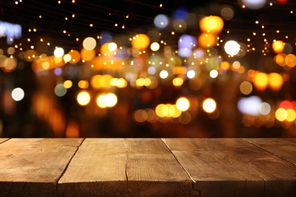 Pozadí dřevěného stolu před abstraktní rozmazanou světlíky v restauraci — Stock fotografie