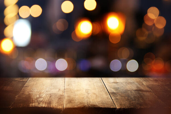 фон деревянного стола перед абстрактными размытыми огнями ресторана
