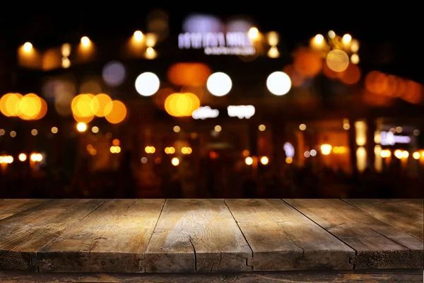 Tło drewnianego stołu przed abstrakcyjnym niewyraźne światła restauracji — Zdjęcie stockowe