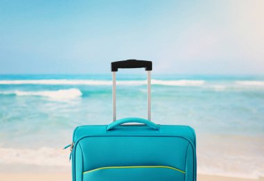 Tatil. seyahat konsepti. tropikal arka plan önünde mavi bavul