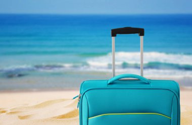 Tatil. seyahat konsepti. tropikal arka plan önünde mavi bavul