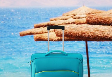 Tatil. seyahat konsepti. tropikal arka plan önünde mavi bavul