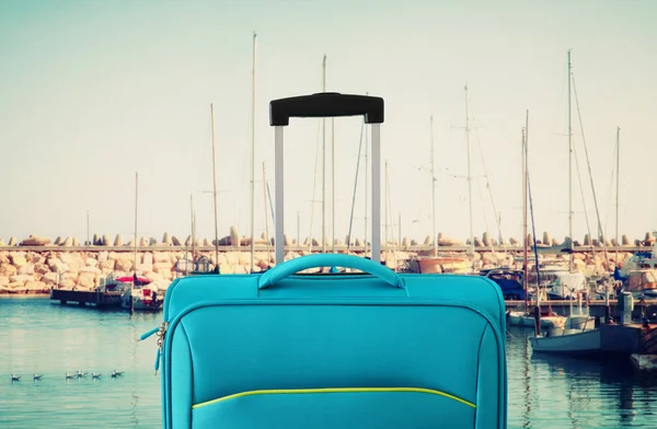 Wakacje. koncepcji podróży. niebieski walizka Infront na tle Marina — Zdjęcie stockowe