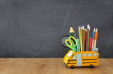 eğitim ve okul kavramına geri dön. kalemler sınıf kara tahta önünde ahşap masa üzerinde otobüs gibi standı