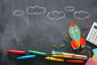 Eğitim. Okul konseptine geri dönelim. Kağıttan yapılmış roket kesimi ve karatahta arka planının üzerine boyanmış. Üst görünüm, düz uzanma